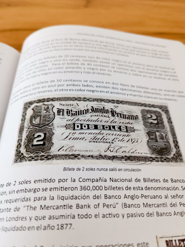 Libro Historia del papel moneda en el Perú abierto en la sección de billete de dos soles.
