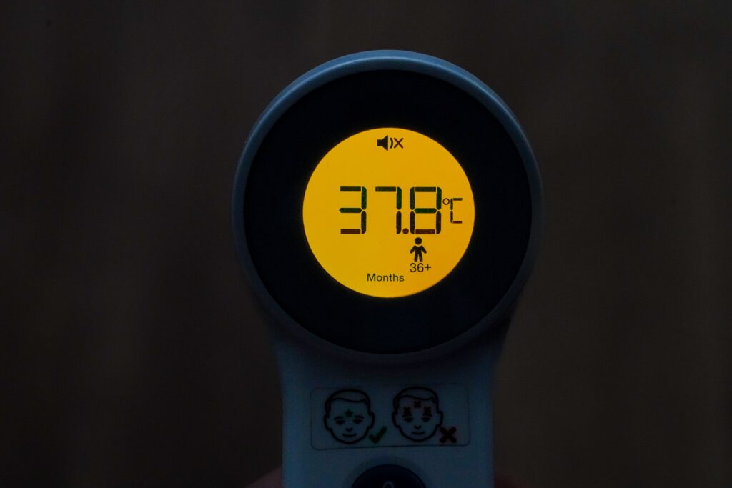 Digital thermometer that reads 37.8 degrees Celsius